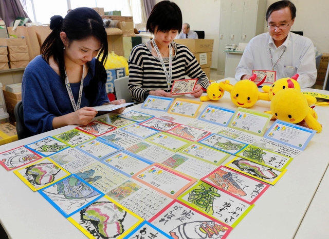小学生から届いた絵手紙を確認する事務局のスタッフら＝神戸マラソン実行委員会事務局