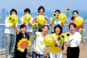 震災復興のシンボル「ひまわり」を手に応援する人たち（神戸マラソン大会事務局提供）