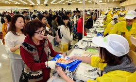 間もなく本番。受け付けに並び、ナンバーカードを受け取るランナーたち＝１３日午後、神戸国際展示場（撮影・田中靖浩）