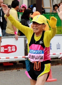 両手を挙げてフィニッシュする上野山馨さん＝１５日午後、神戸市中央区港島中町６