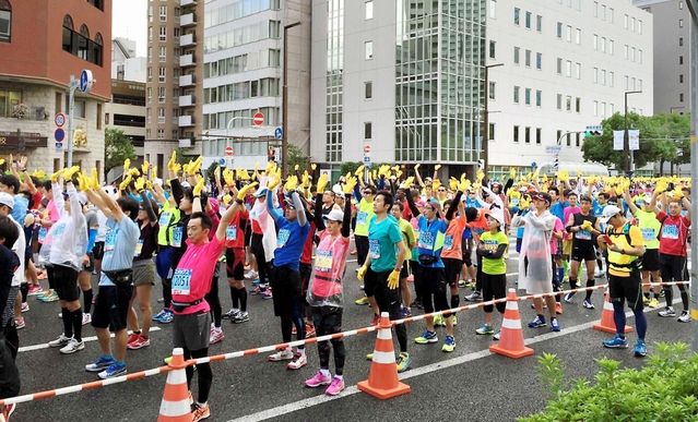スタート地点で復興の象徴「ひまわりの手袋」を振るランナーの姿に、幸枝さんはとても感動したという（幸枝さん撮影）