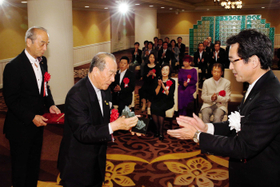 神戸新聞平和賞を受ける植月正章さん（中央）、高士薫・神戸新聞社社長（右）＝８日午前、神戸メリケンパークオリエンタルホテル（撮影・大山伸一郎）
