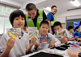 完成した作品を手に取る児童ら＝御蔵小学校