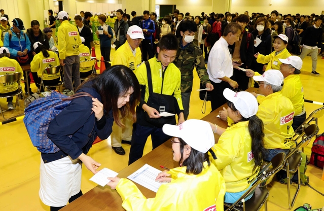 受け付けのために列をなす神戸マラソンの参加ランナーたち＝１８日午後、神戸国際展示場（撮影・小林良多）