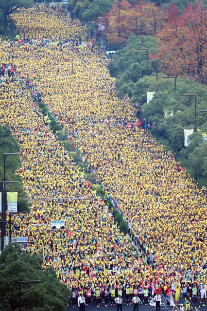 黄色い手袋を一斉に掲げるランナー＝２０日午前、神戸市中央区（撮影・岡本好太郎）