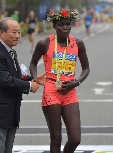 女子優勝を決め、オリーブの冠を頭に植月正章・大会実行委員会会長（左）と握手するジャクリーン・キプリモ（撮影・風斗雅博）