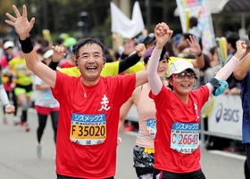 笑顔でゴールする熊本市の坂本淳一さんと、ひろ子さん＝神戸市中央区（撮影・大山伸一郎）