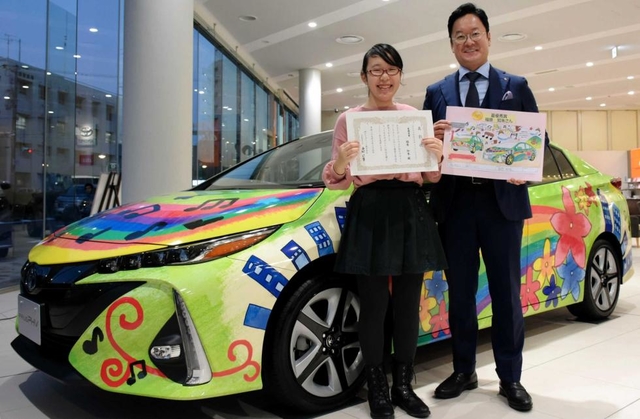 プリウスＰＨＶのラッピング車両と、デザインコンテストの最優秀賞に輝いた福原知朱さん（左）と神戸トヨペットの西村公秀社長＝東灘区御影中町３