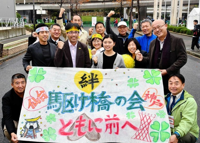 本番に向け士気を高める新妻英敏さん（２列目左から２人目）と娘の彩乃さん（同３人目）を囲む「駆け橋の会」メンバー＝神戸市中央区港島中町６（撮影・後藤亮平）
