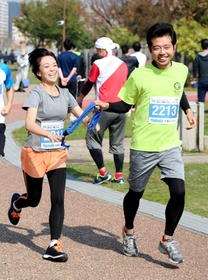 たすきリレーをする坂山真里緒記者（左）と阪口真平記者＝神戸市中央区小野浜町２（撮影・井上駿）