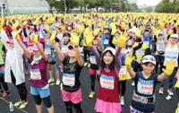 第６回神戸マラソンで、黄色の手袋を付けた両手を空に広げるスタート前の参加者