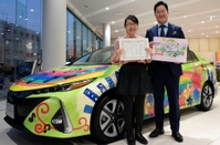 プリウスＰＨＶのラッピング車両と、デザインコンテストの最優秀賞に輝いた福原知朱さん（左）と神戸トヨペットの西村公秀社長＝東灘区御影中町３