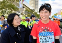 祖父への思いを胸に完走した乾聖陽さん（右）を、母の喜代美さんが出迎えた＝神戸市中央区港島中町６（撮影・後藤亮平）