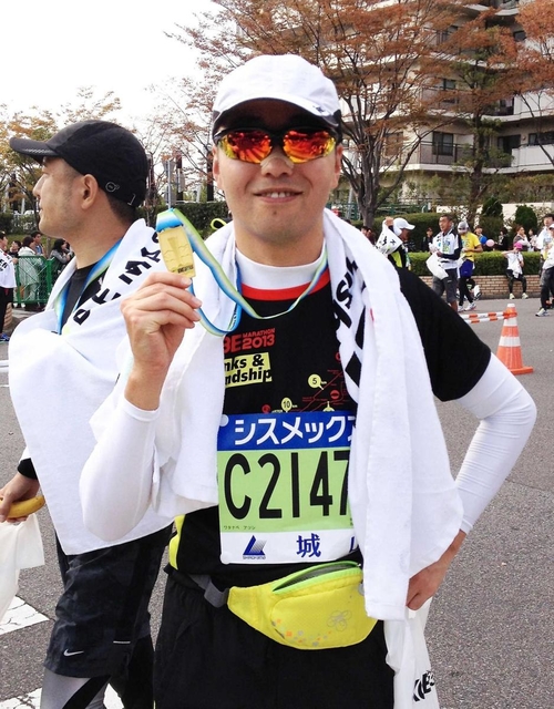 完走メダルを手にする渡辺敦さん（２０１３年の第３回神戸マラソン）