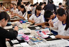 モデルのシューズを見ながら絵手紙を描く児童ら＝神戸市兵庫区和田宮通６、市立和田岬小