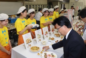 考案したメニューを説明しながら手渡す学生たち＝神戸市西区伊川谷町有瀬