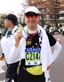 完走メダルを手にする渡辺敦さん（２０１３年の第３回神戸マラソン）
