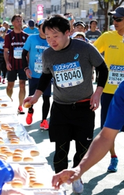 給食地点でパンを手に取る篠原記者＝神戸市中央区東川崎町１（撮影・山崎竜）