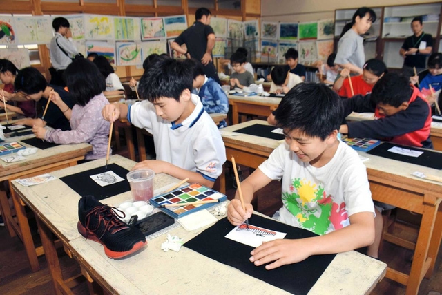 ランニングシューズの絵を描く児童ら＝神戸市兵庫区材木町