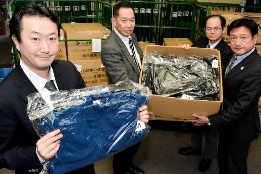 発展途上国に届ける衣類をクリーニングした石井大社長（左）＝神戸市灘区琵琶町３