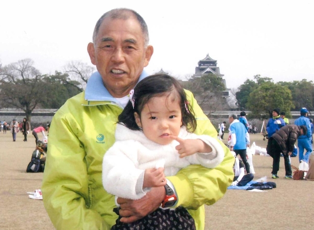 神戸マラソンを楽しみにしている西川秀文さん。後方は震災前の熊本城（２０１４年）