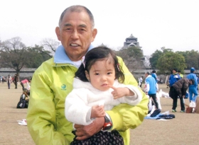 神戸マラソンを楽しみにしている西川秀文さん。後方は震災前の熊本城（２０１４年）