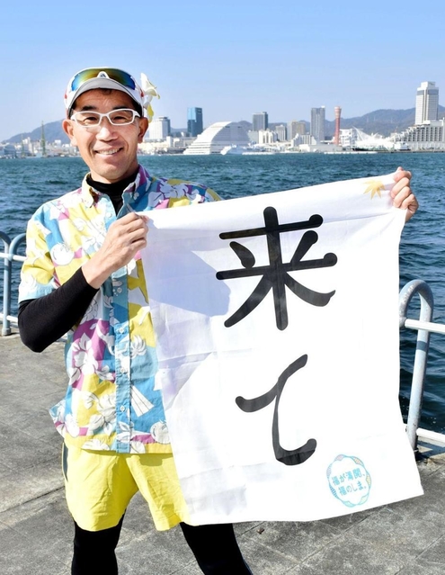 福島県いわき市から参加する田島裕司さん。台風被害を知ってもらうための旗を手に、港町を駆ける＝神戸市中央区港島２