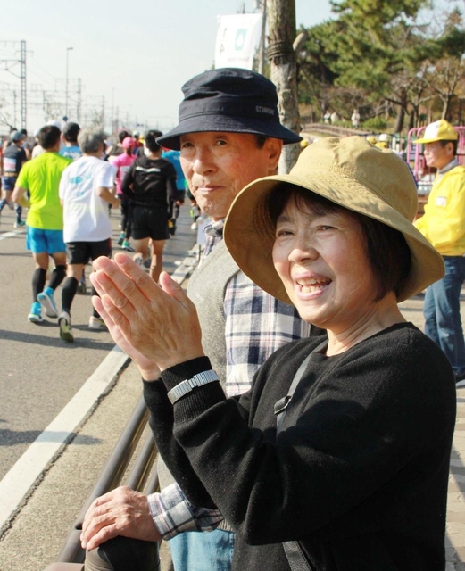 ランナーに「頑張れー！」と声を掛ける山中さん夫妻＝神戸市須磨区