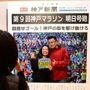 新聞の号外紙面を模した撮影スポットで記念撮影するランナーら＝神戸市中央区港島中町６（撮影・秋山亮太）