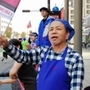 「頑張れ」と旗を振る林誠二さん＝神戸市兵庫区