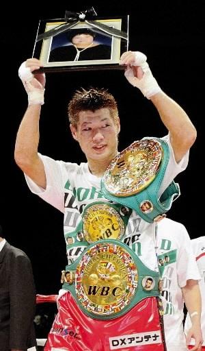 ２階級制覇を果たし、母・裕美子さんの遺影を掲げる長谷川穂積＝名古屋市南区、日本ガイシホール