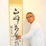 松方正義の書「山は呼ぶ万歳の声」を解読する松宮貴之さん＝滋賀県多賀町のギャラリー「松宮書法館」