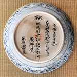 浮世絵の「横綱土俵入り」を描いた古伊万里大皿の裏に、筆文字が記されていた