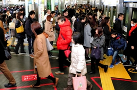 乗降客が行き交う朝の三宮駅。ホームに赤線を引き、降車客の通路を確保している＝神戸市中央区、ポートライナー三宮駅