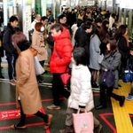 乗降客が行き交う朝の三宮駅。ホームに赤線を引き、降車客の通路を確保している＝神戸市中央区、ポートライナー三宮駅