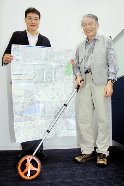 六甲全山縦走路を測ったロードメジャーを手にする守屋益男さん（右）と、完成した地図を広げる次男二郎さん＝神戸新聞社