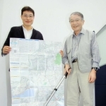六甲全山縦走路を測ったロードメジャーを手にする守屋益男さん（右）と、完成した地図を広げる次男二郎さん＝神戸新聞社