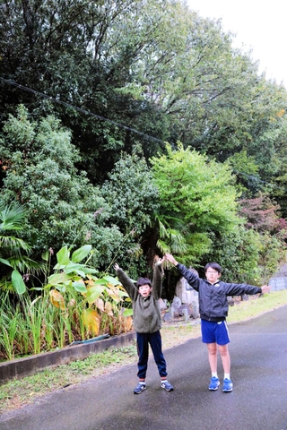 校舎の後ろにそびえる裏山を紹介する中部遥杜さん（右）と颯介さん＝三木市平田