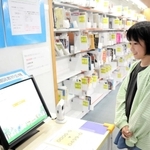 予約していた本を借りる新開彩永さん。本は奥の棚に届いていて、機械で確認することができる＝神戸市東灘区住吉東町２