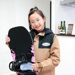 新しく買ってもらったスノーボードを抱えて笑顔の松崎心海さん。ウェアも大人っぽくてお気に入りだ＝高砂市阿弥陀町