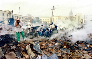 阪神・淡路大震災で倒壊、焼失した住宅の跡で行方不明者を捜す人たち＝１９９５年１月１９日、神戸市須磨区千歳町２