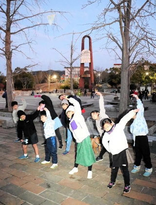 地元住民をはじめ、大勢が毎朝集まる名谷公園のラジオ体操。大西凜さん（前列右から２人目）、縁さん（前列右）の姉妹も大きな動きを見せる＝神戸市須磨区西落合７、名谷公園