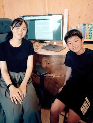 姉の和叶（左）さんは携帯電話の表示を英語にチェンジ。弟、貫真さん（右）も英語が大好き＝神戸市垂水区