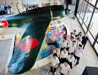 館内に展示されている実物大の戦闘機の模型と北条高校「うずらの班」の生徒ら＝加西市鶉野町