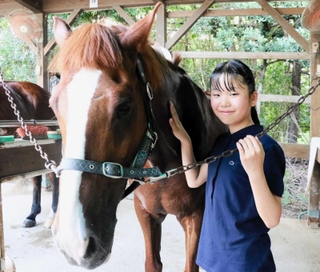 螢と松内愛莉さん＝明石市大久保町、明石乗馬協会