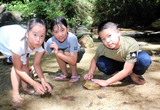 水遊びを楽しむ（左から）中山凛香さん、田畑杏莉さん、中山智仁さん＝神戸市兵庫区烏原町