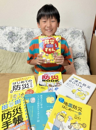 目を通してきた防災の本と金野俊太郎さん＝神戸市内