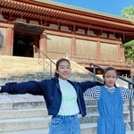 本堂の前で両手を広げる大沼美瑛さん（左）と塩谷茉那さん＝いずれも神戸市西区伊川谷町前開、太山寺