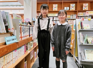 奥村佳歩さん（左）と高栁詩乃さんがお気に入りという児童書のコーナー＝加古川ウェルネスパーク図書館