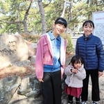 左の石が鵺塚。矢尾成璃子さん（左）と船越えれなさんと妹の芹夏さん。伝説は受け継がれていく＝芦屋市浜芦屋町